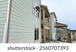 Castle Pines, Colorado USA - January 18, 2023-A view of the rear exterior of multiple new residential homes under construction in a suburban neighborhood. The homes feature modern siding, large