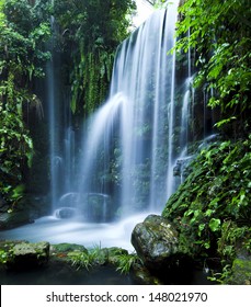 Castle Ruins Surrounded By Rainforest Gardens, Right Beside A Stunning Waterfall.