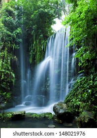 Castle Ruins Surrounded By Rainforest Gardens, Right Beside A Stunning Waterfall.