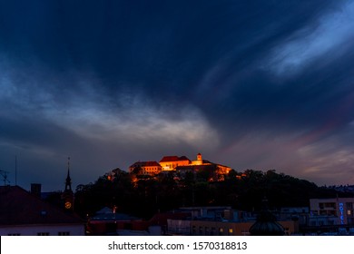 Castle Spilberk Brno city slow moving clouds captured just from castle turn public light on going from blue hour to night time with colored sky and clouds.