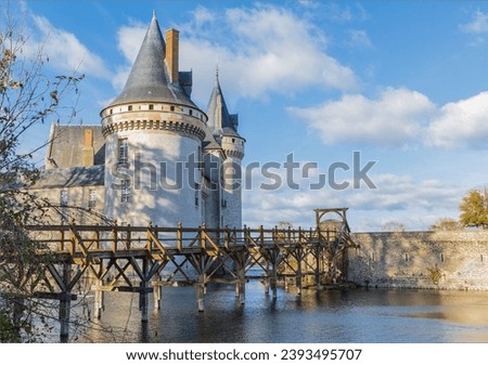 Castle with tall turrets and a wooden bridge crossing the moat