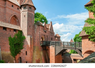 The Castle of the Teutonic Order in Malbork by the Nogat river. Poland. The entrance group of the castle passes through a wooden bridge. Horizontal format. - Shutterstock ID 2286442627