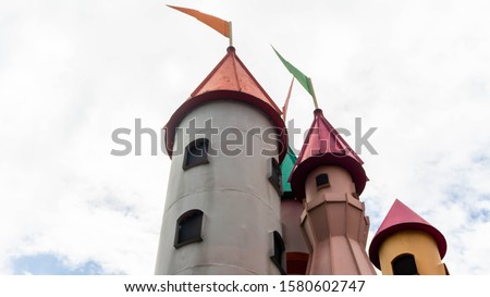 Castle tower with mini flag at the peak and white sky as background at Sunway Lagoon theme park in Bandar Sunway.