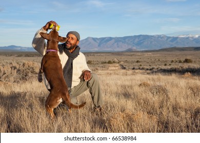 Casual African American Man Playing With His Dog Outdoors