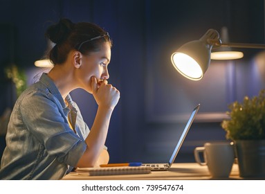 Casual Beautiful Woman Working On A Laptop At The Night At Home.