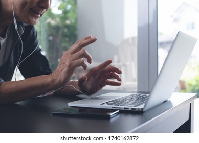 Casual Business Man With Headphone Making Facetime Video Calling, Teleconference, Using Zoom Meeting Online App Via Laptop Computer At Home Office. Male Tutor Giving Online Class, E-learning