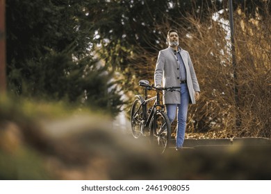 A casual business man is walking down a set of stone steps in an urban park with his mountain bike. - Powered by Shutterstock