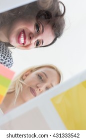 Casual Business People Using Mobile Phone  And Graphs At Modern Stylish Office, Smiling. Shot Thrugh Glass Table, Low Angle