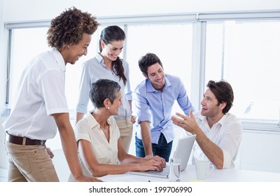 Casual Business Team Having A Meeting Using Laptop In The Office