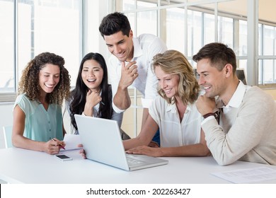 Casual Business Team Having A Meeting Using Laptop In The Office