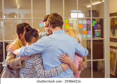 Casual Business Team Standing In A Cirlce In The Office