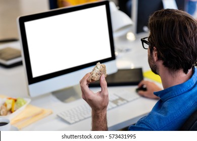 Casual Businessman Eating A Sandwich In Front Of The Computer