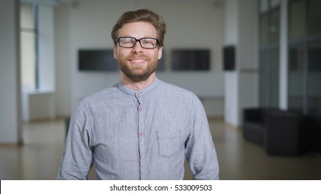 Casual businessman is standing in corporate office lobby and smiling. - Shutterstock ID 533009503