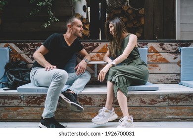 Casual dressed male and female lovers enjoying time for flirting during date time in sidewalk cafe, happy diverse hipster guys discussing positive friendship and relationship smiling outdoors