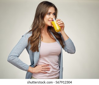 casual dressed woman drink orange juice with glass. gray isolated portrait smiling girl. - Powered by Shutterstock