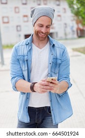 Casual Fashion Guy Taking A Walk With His Mobile In The City