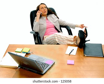 Casual Female Executive Kicked Back At Her Desk Talking On Cell Phone