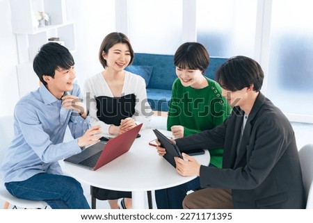 A casual group of four Asian men and women having a meeting.