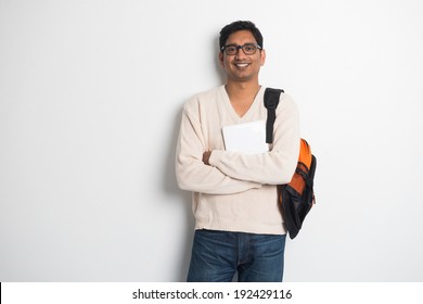 casual indian male student on a sweater and tablet