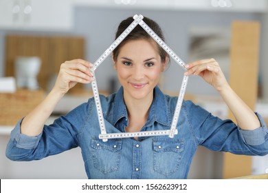 casual lady making house shape from a measuring ruler