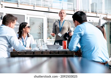 Casual Lunch Meeting In Open Restaurant In Front Of The Business Building. Young Employees At Start Up Meeting In Outdoor Coffee Break