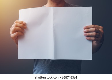 Casual Man Holding Blank A3 Paper Spread As Copy Space For Magazine And Newspaper Text Or Graphic Design Mock Up