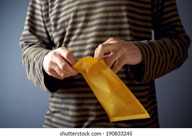 Casual Man Is Opening Yellow Document Postal Envelope