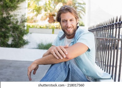 Casual man smiling at camera on a sunny day in the city