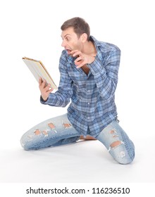 Casual Mature Man In Ragged Jeans Kneeling Barefoot On The Floor, Communicates Via Tablet Pad