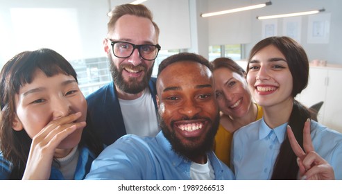 Casual Multiethnic Business People During Break From The Work Taking Selfie. Pov Shot Of Diverse Happy Colleagues Smiling At Camera Taking Photo Together In Office