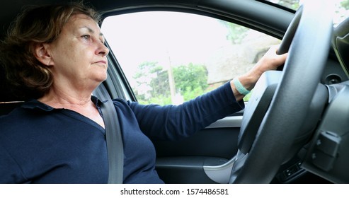 
Casual Older Woman Driving Making A Turn Holding Steering Wheel