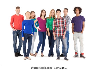 Casual people. Full length of cheerful young people smiling at camera while standing isolated on white