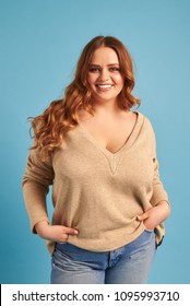 Casual plump woman with hands in pocket posing at the camera 