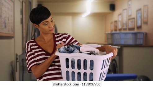 Casual Portrait Of Young Mom Doing Laundry At Laundromat