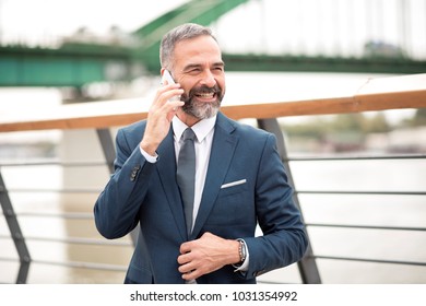 Casual Senior Business Man Walking The Street And Talking On His Cell Phone, Urban Outdoor Area