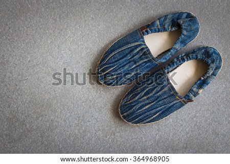 Casual shoes of men and women handmade with blue jean on gray grunge background