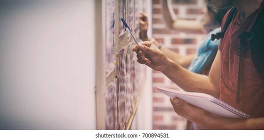 Casual Students Searching Something On Notice Board In College