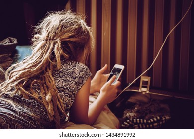 Casual Unidentified Girl Laying Down On Bed In Her Room And Scrolling Through Smartphone. Modern Communication Concept. Instagram Style Filter.