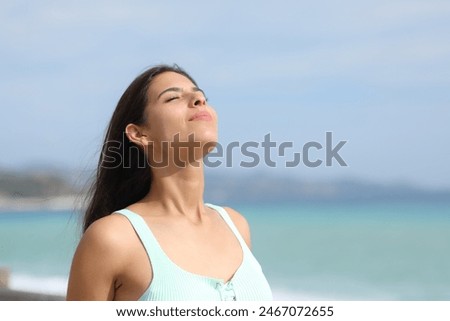 Casual woman is breathing fresh air on the beach