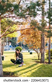 Casual Woman Sitting On Green Grass And Working Part Time With Laptop And Relax In Summer Camp. Copy Space. Drinking Coffee To Go, Freelance Using Technology