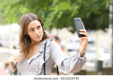 Casual woman taking selfie with smart phone in the street - Powered by Shutterstock