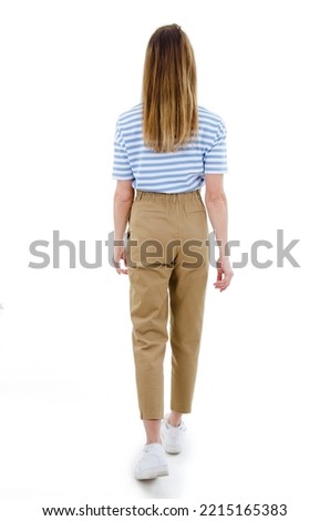 Casual woman walking away from the camera. Isolated on white background. Studio shot. Full length
