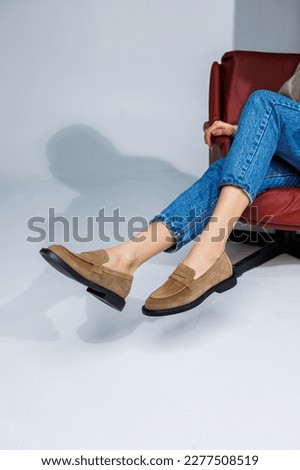 Casual women's fashion. Classic shoes for women. Slender female legs in trousers and brown stylish casual loafers. Women's comfortable summer shoes.