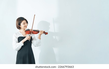 Casual young asian woman with violin. - Powered by Shutterstock