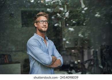 Casual young businessman behind windowpane in office - Powered by Shutterstock