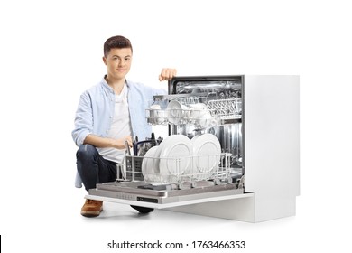 Casual young man next to an open dishwasher isolated on white background
