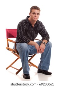 Casual Young Man Seated In Directors Chair.