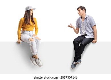 Casual Young People Sitting On A Blank Panel And Having A Conversation Isolated On White Background