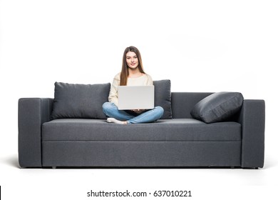 Casual Young Woman Lying On Couch And Using Laptop At Home