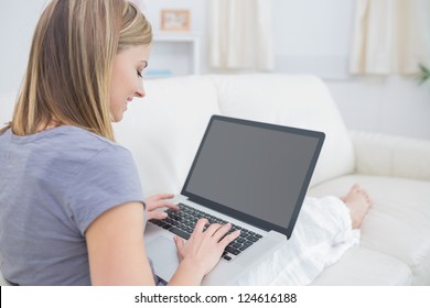 Casual young woman using laptop in living room at home. Working from home in quarantine lockdown. Social distancing Self Isolation - Powered by Shutterstock